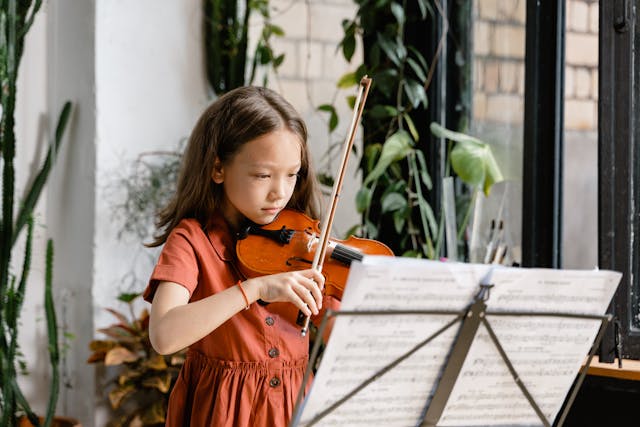 une petite fille qui joue du violon, la réussite d'un enfant à conserver dans un livre personnalisé